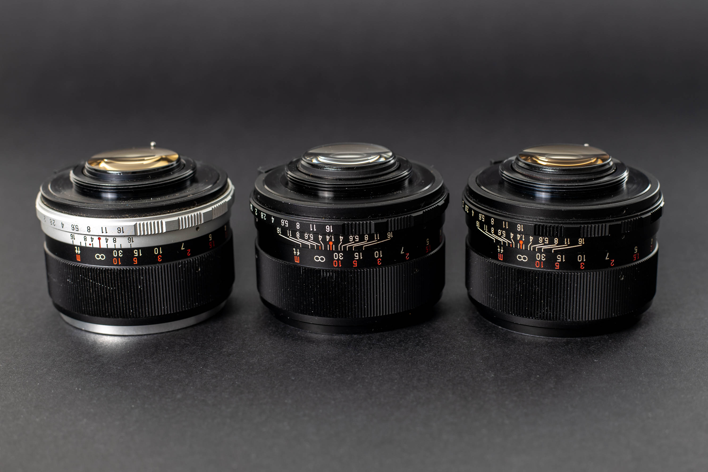 Three Mamiya Sekor 55mm f1.4 lenses - Rear elements at an angle.