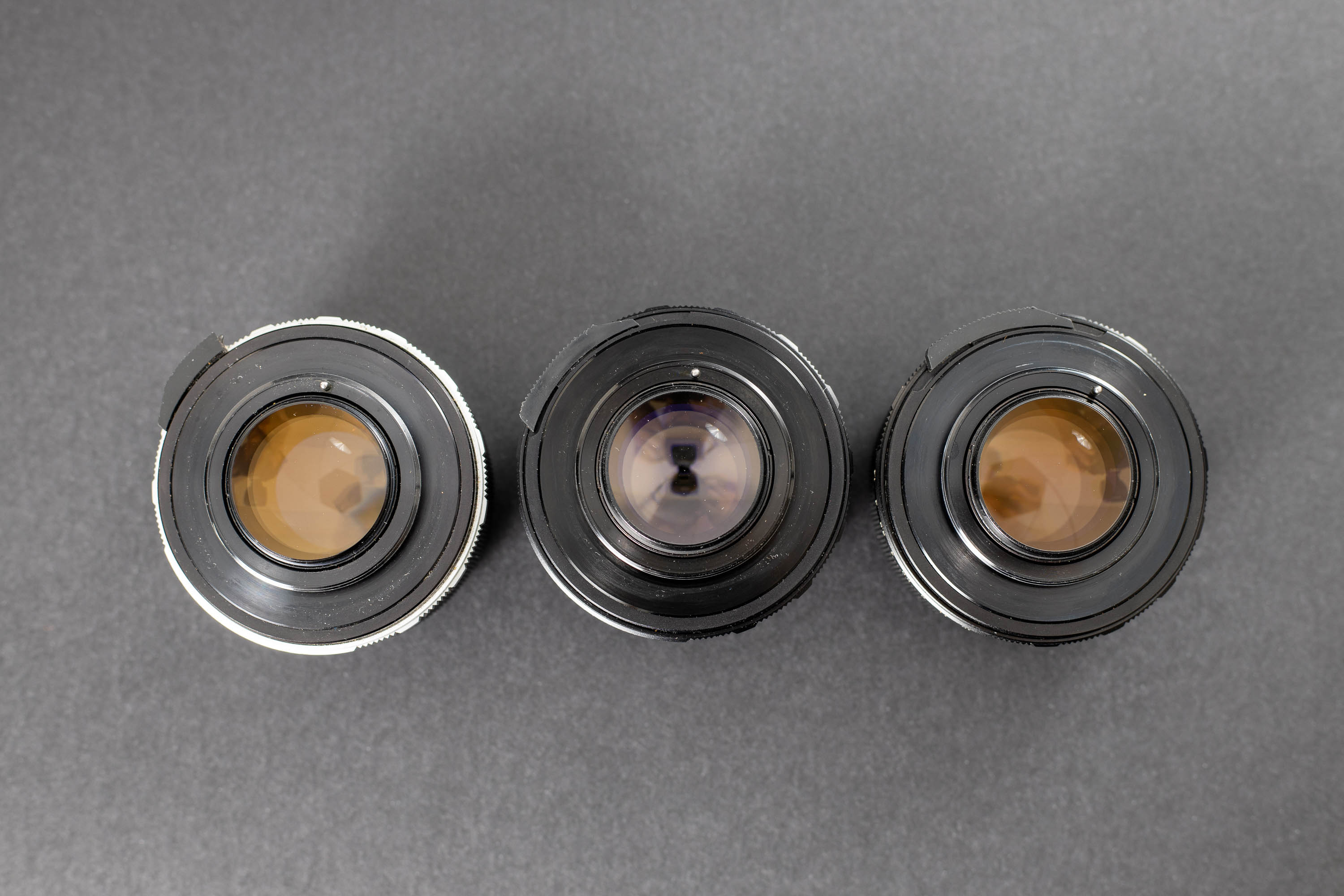 Three Mamiya Sekor 55mm f1.4 lenses - Back view. It is really easy which rear elements have thorium in them.