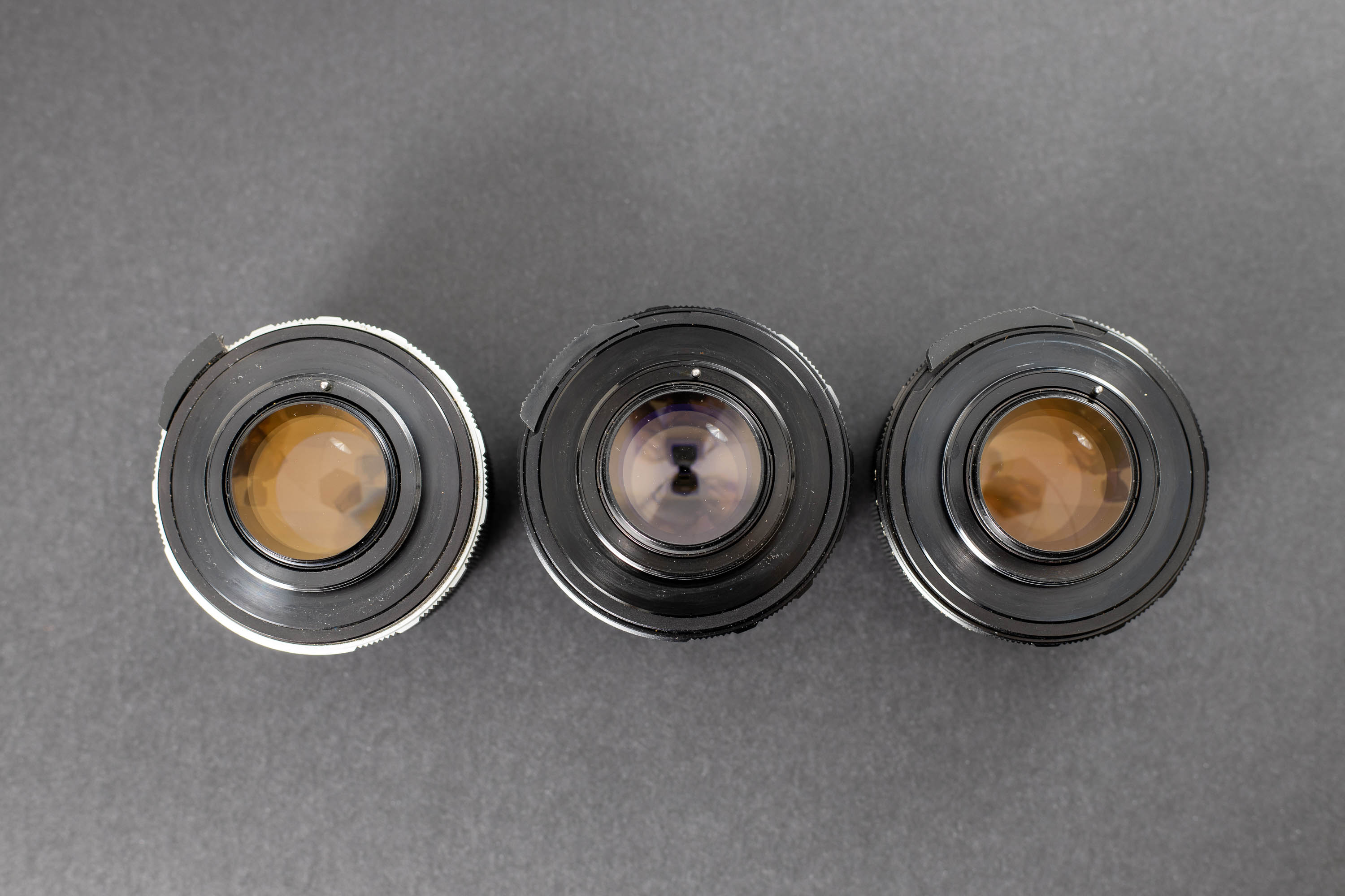 Three Mamiya Sekor 55mm f1.4 lenses - Back view. It is really easy to see which rear elements have thorium in them.