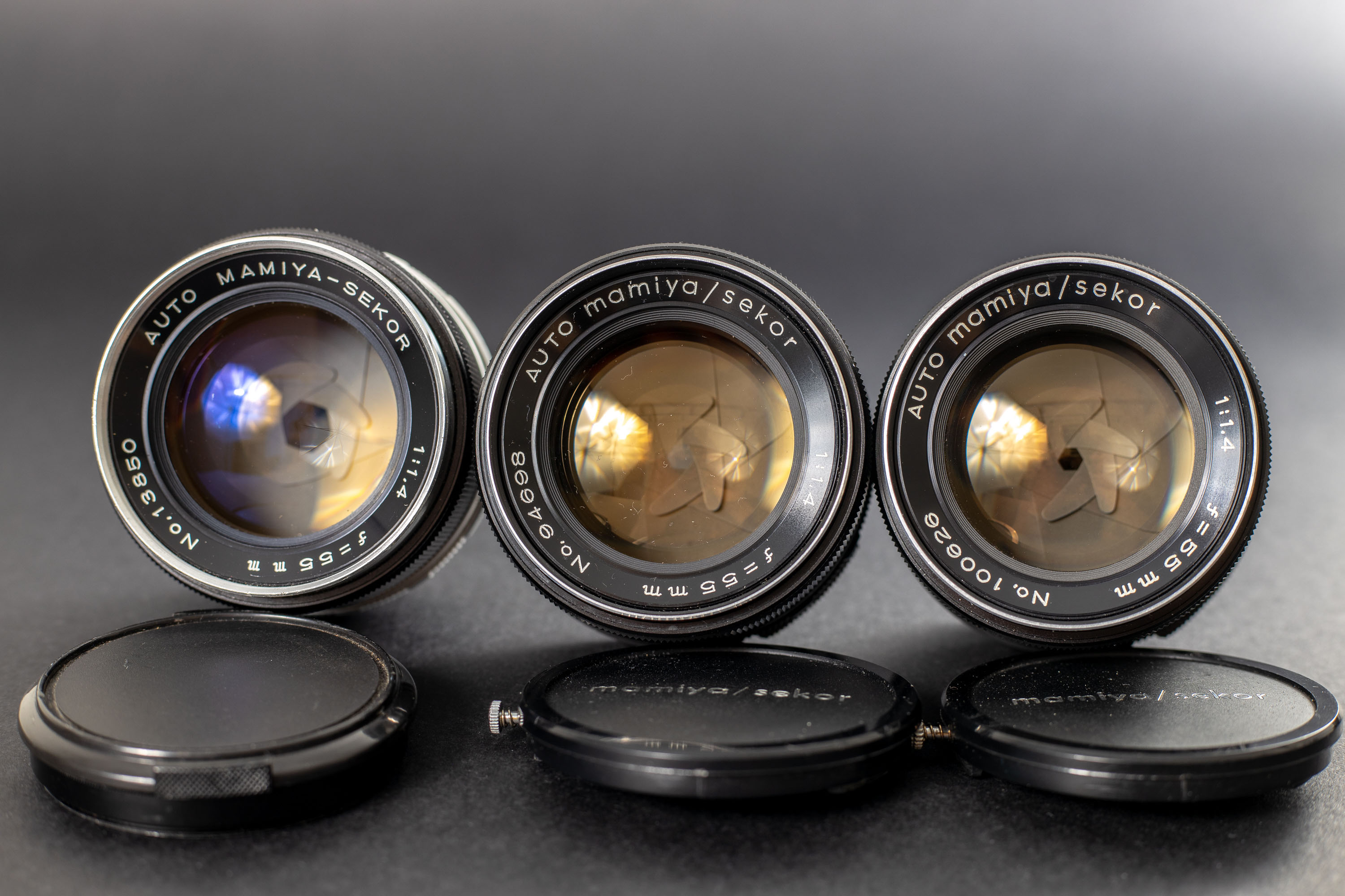 Three Mamiya Sekor 55mm f1.4 lenses - Front view. Notice that yellow tint? Thats radioactive thorium glass.